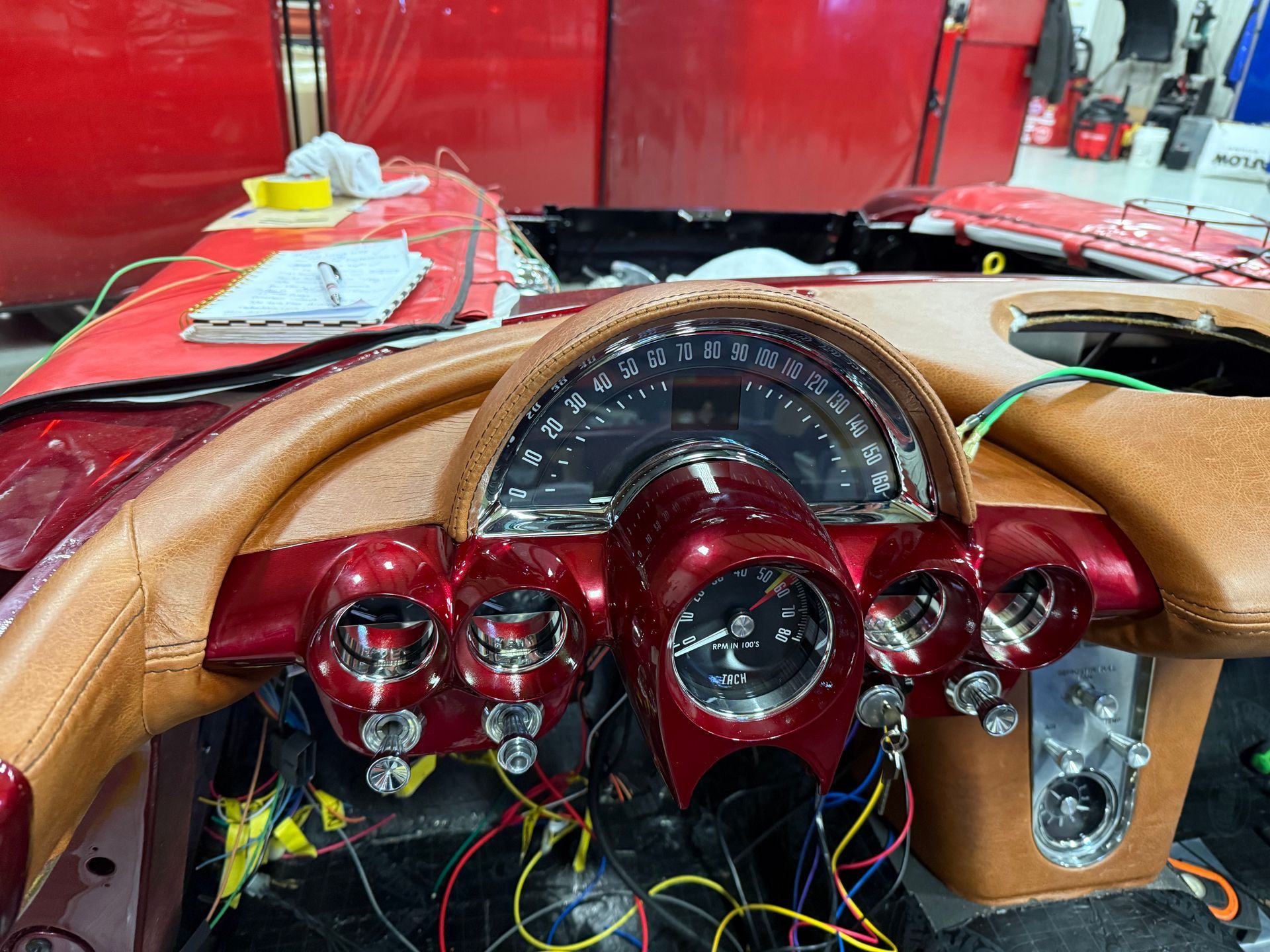 The dashboard of a red car is being worked on