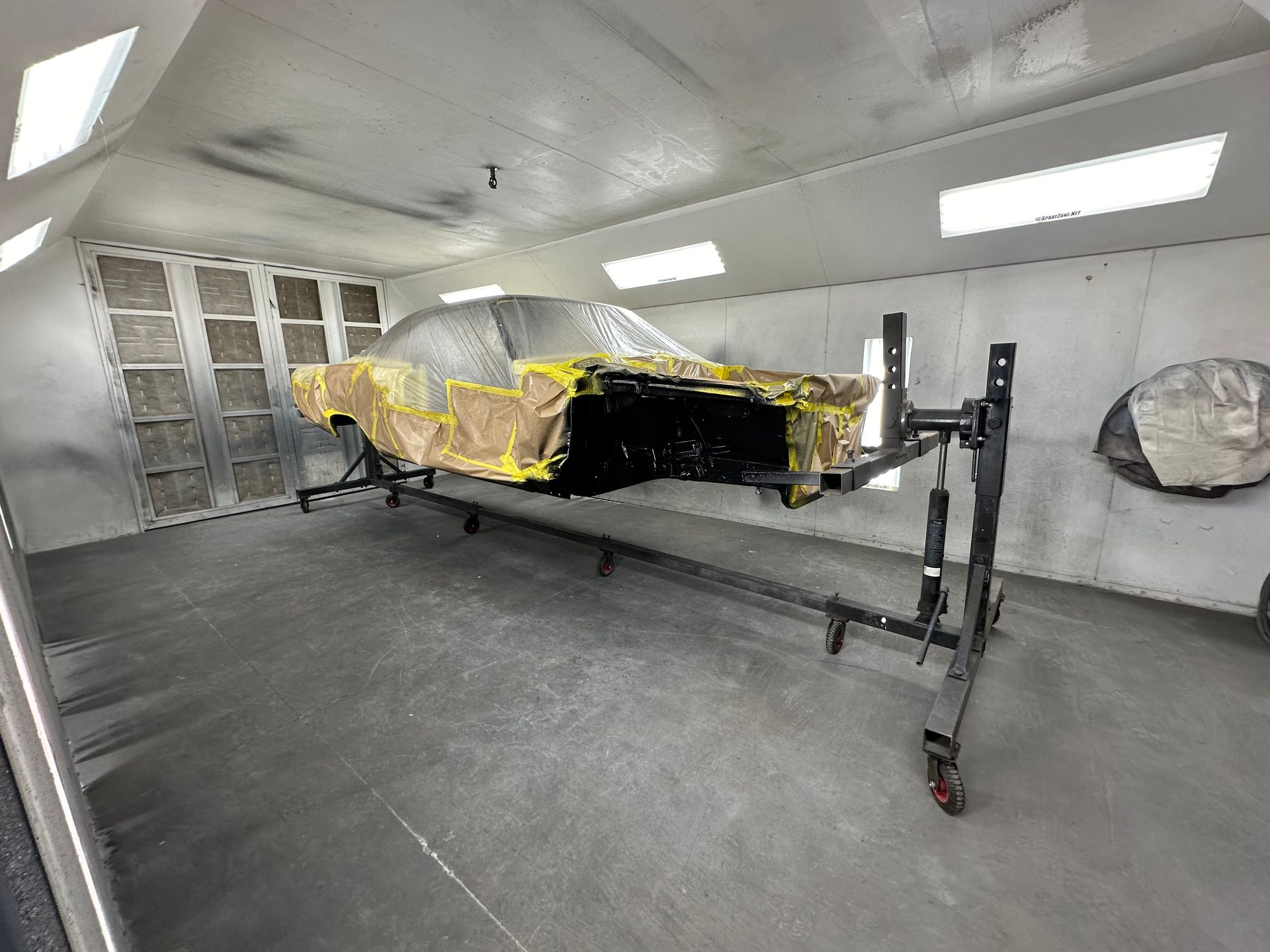 A car is being painted in a paint booth.