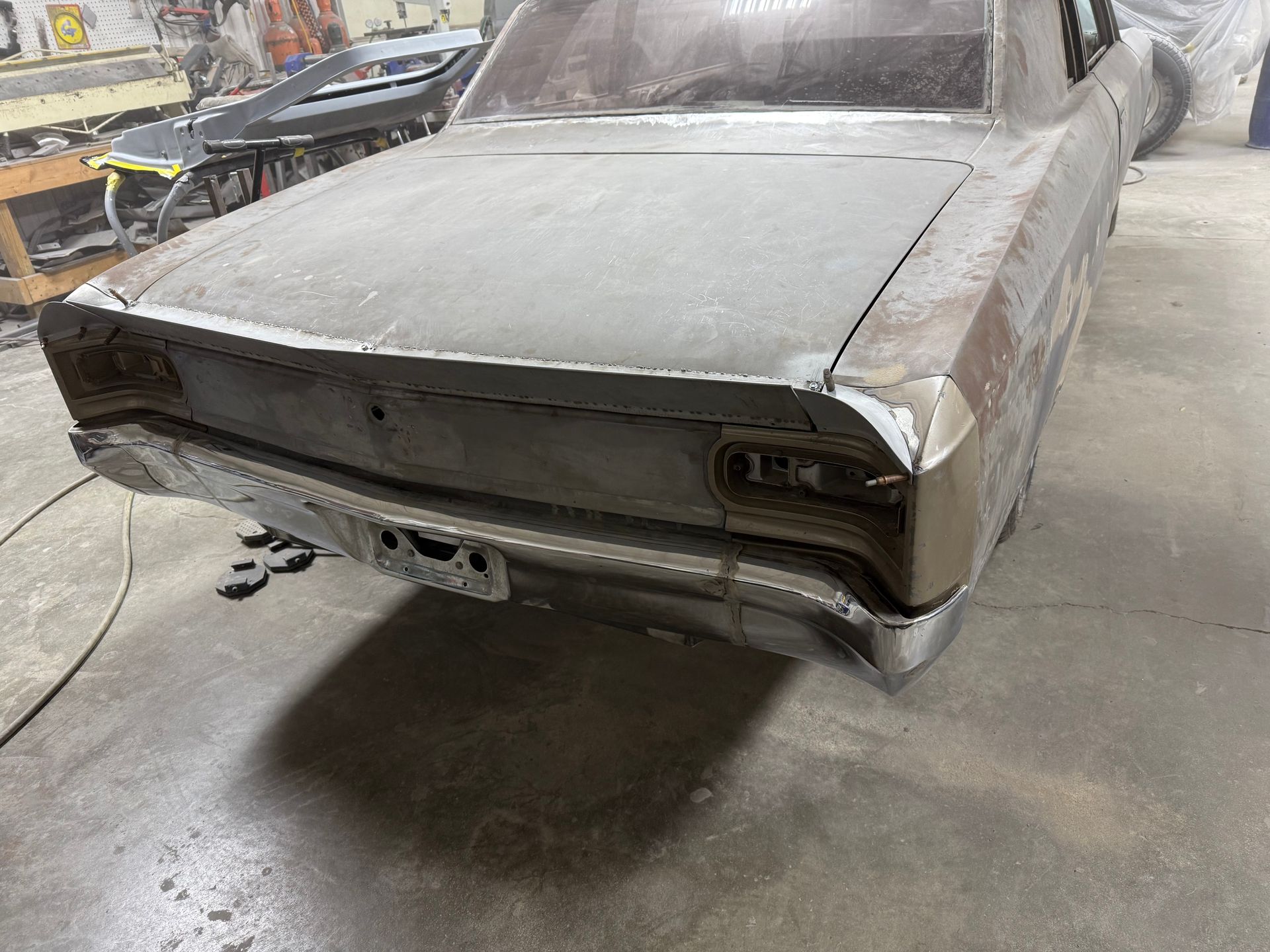 A rusty old car is sitting in a garage.