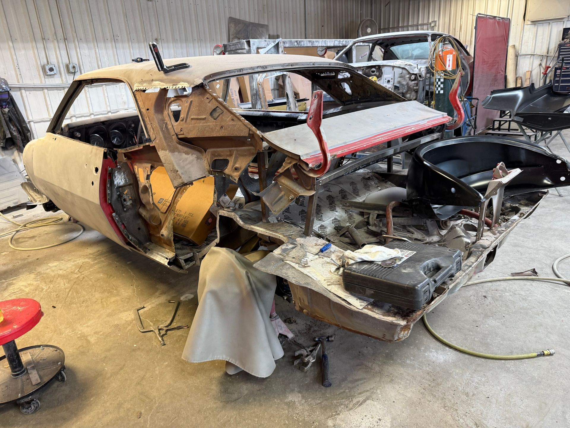 A car is being dismantled in a garage.