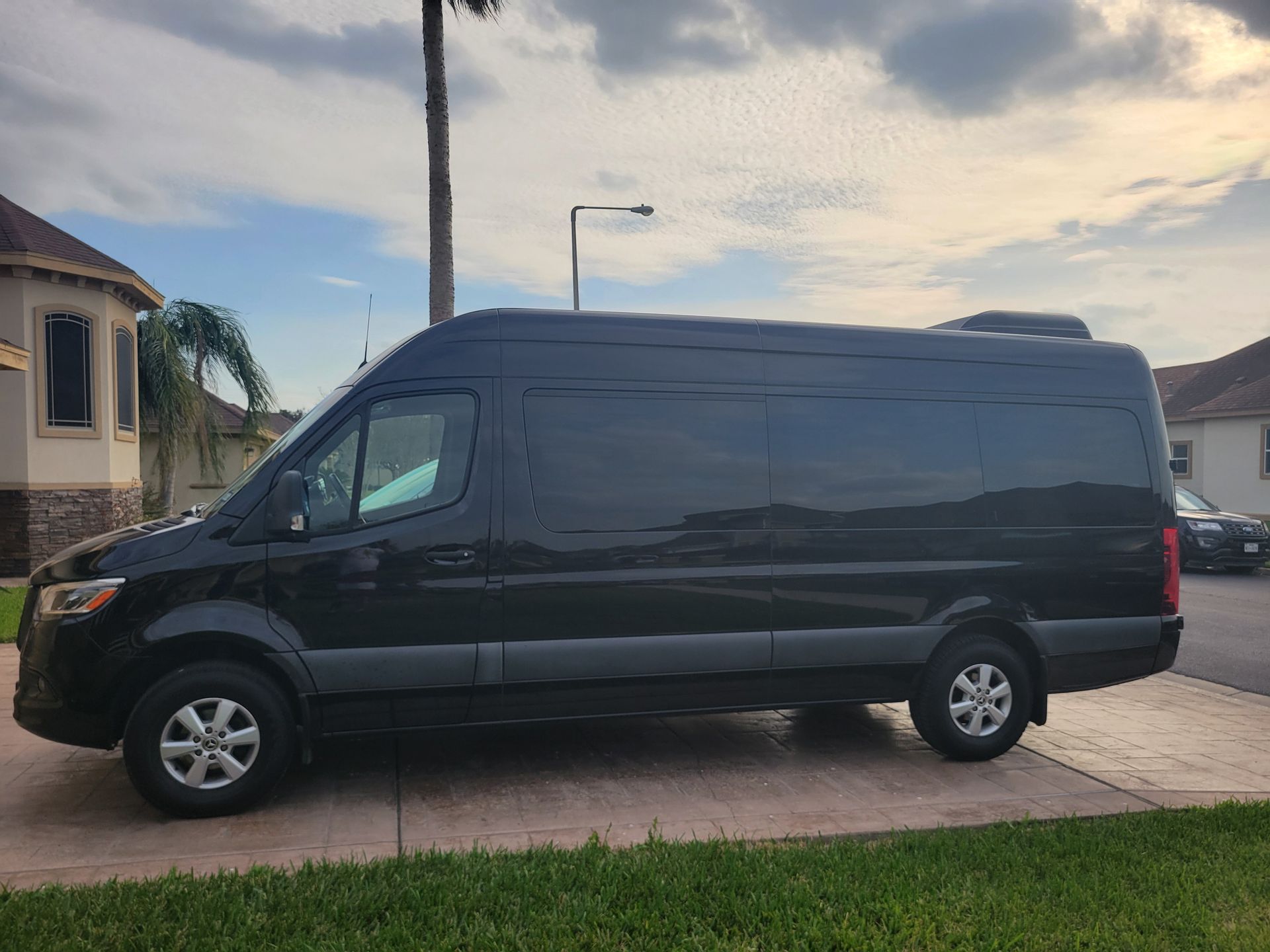 a black van is parked in a driveway in front of a house .