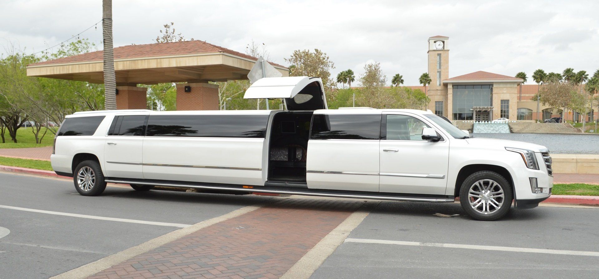 A beautiful white limousine is parked on the side of the road