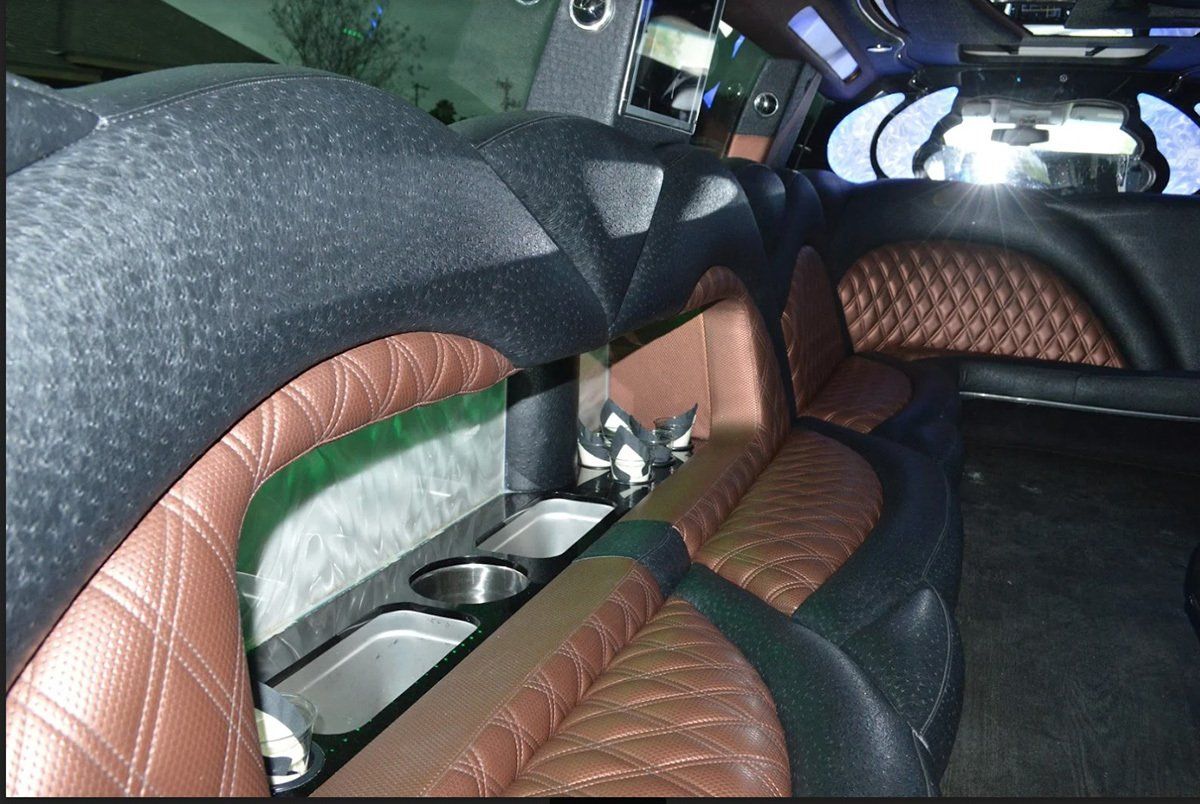 The inside of a limousine with brown and black seats