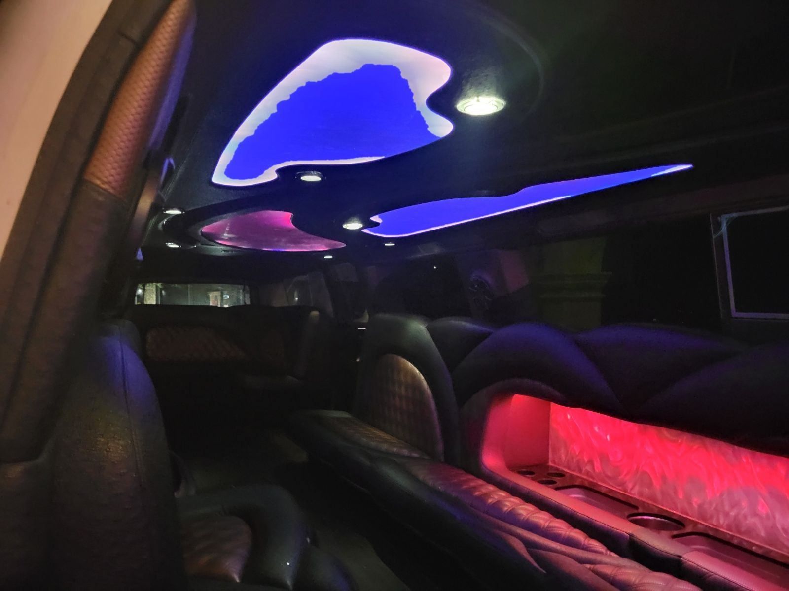 The inside of a limousine with purple and blue lights
