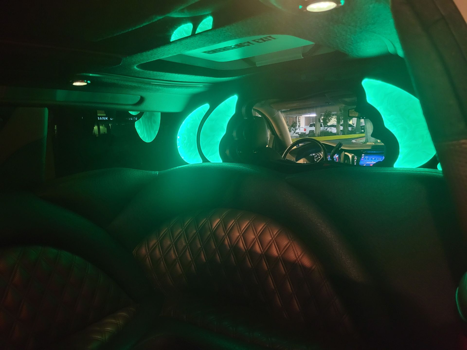 The inside of a car with green lights on the ceiling.