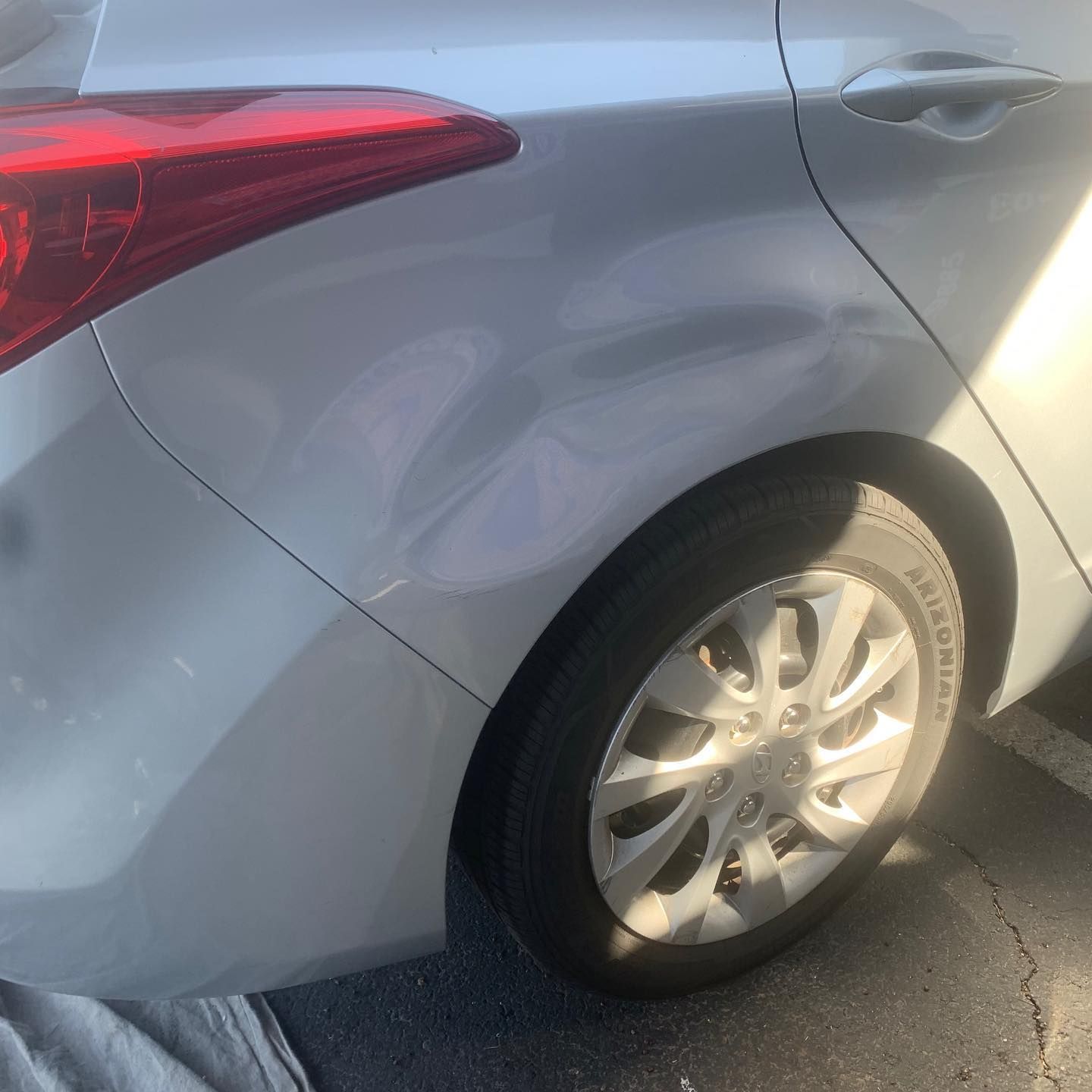 A close-up view of the side of a glossy red car, showing the seam between the door and the rear quarter panel.