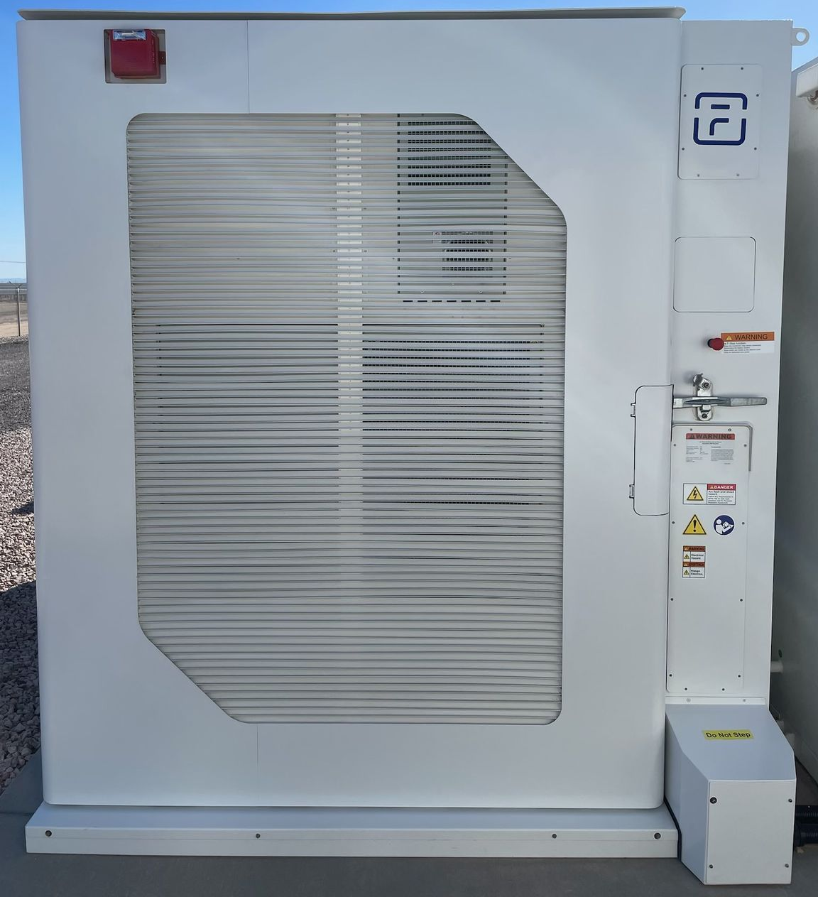 A white outdoor industrial cabinet with a large louvered ventilation panel, mounted on a concrete base.