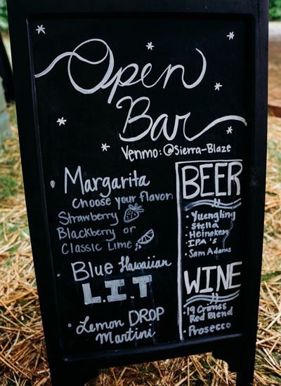 A chalkboard with a list of drinks on it