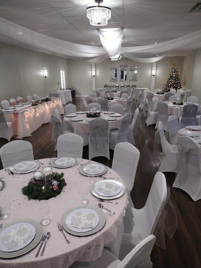 A large room with tables and chairs set up for a wedding reception