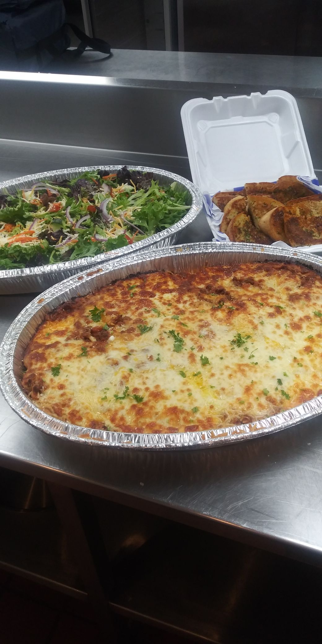 A pizza and a salad are sitting on a table.
