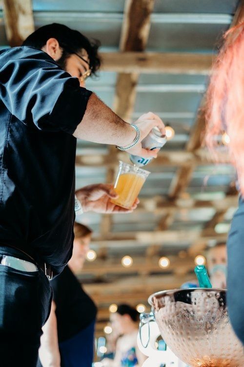 A man is pouring a drink into a glass.