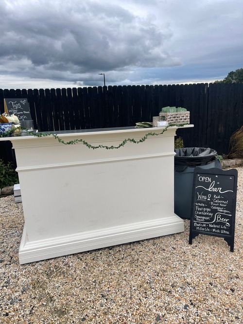 A white bar is sitting in front of a black fence.