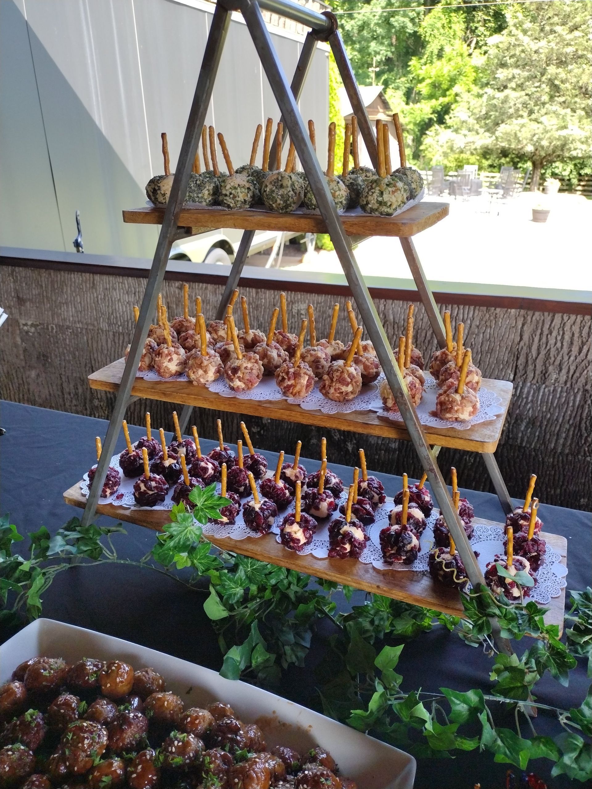 A display of food on a table with a triangle shaped shelf filled with food.