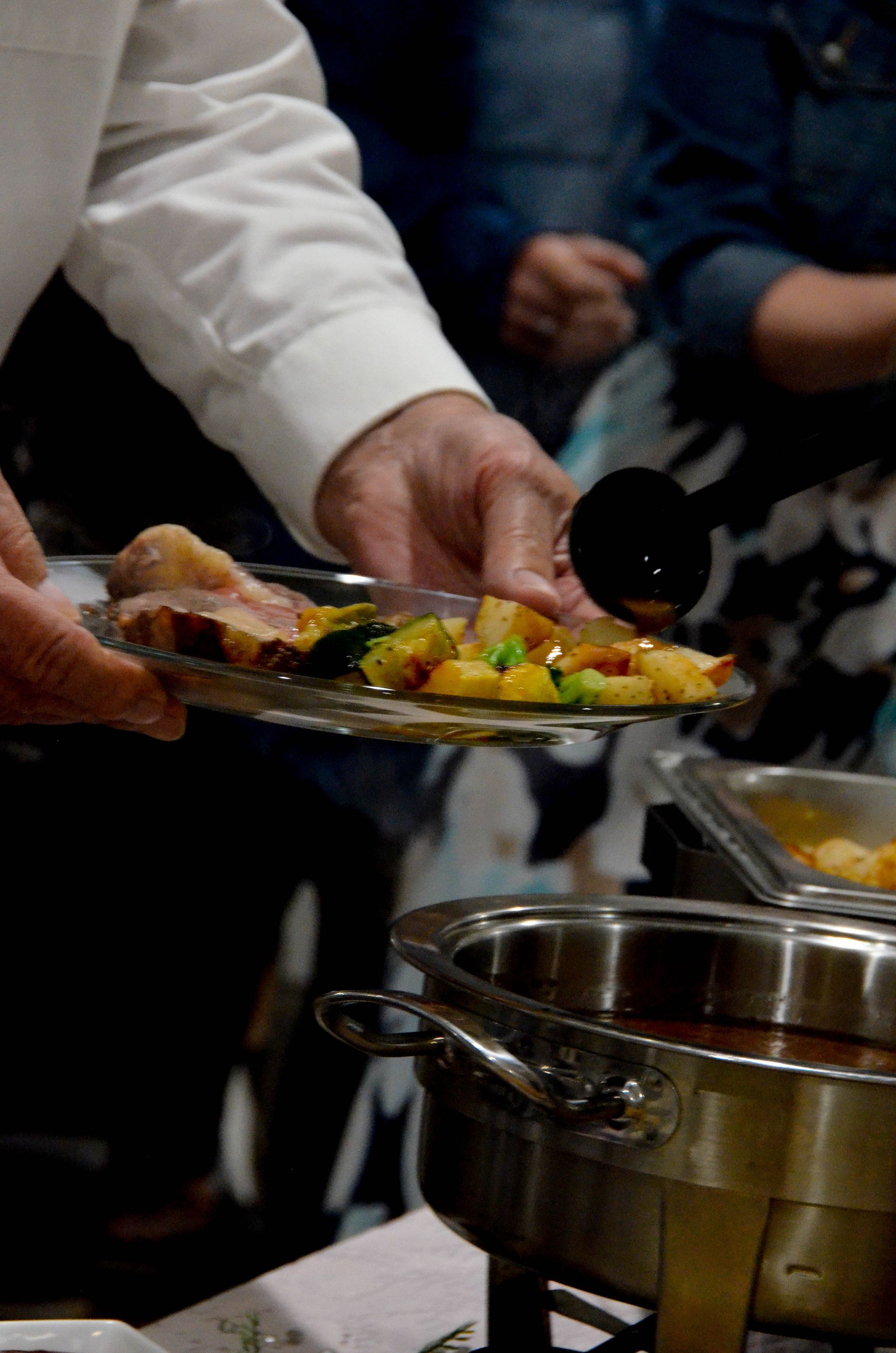 A person is pouring sauce on a plate of food.