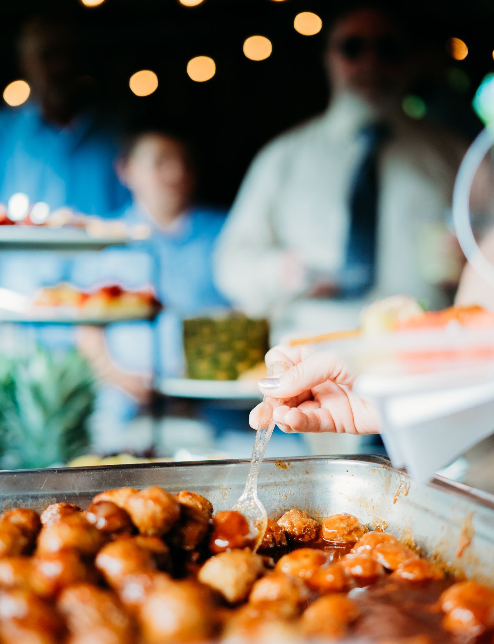 A person is pouring liquid into a pan of food.