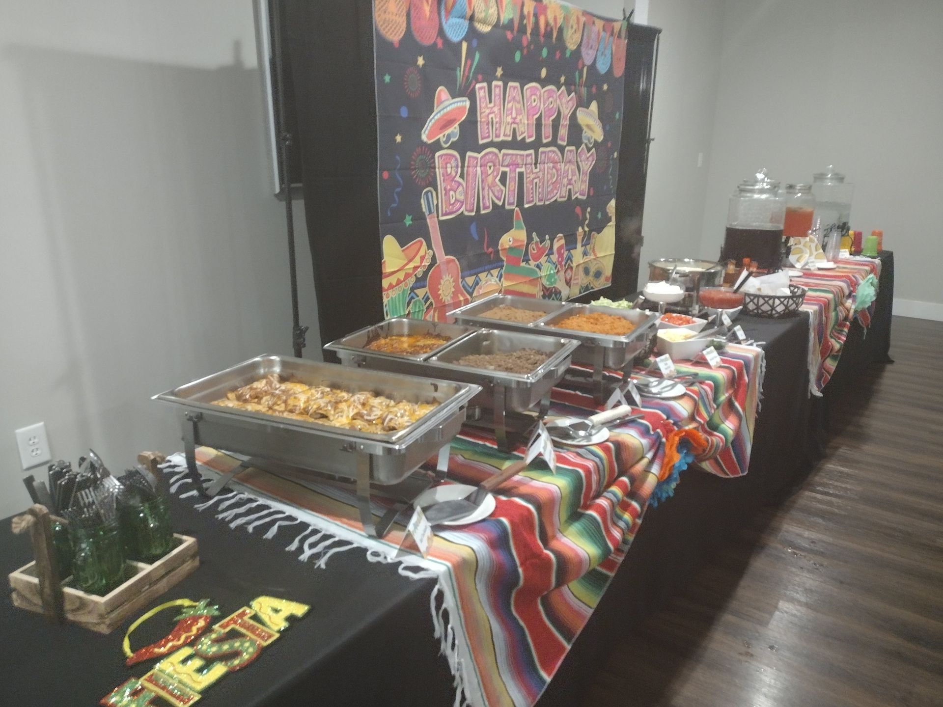 A long table filled with lots of food and drinks for a birthday party.