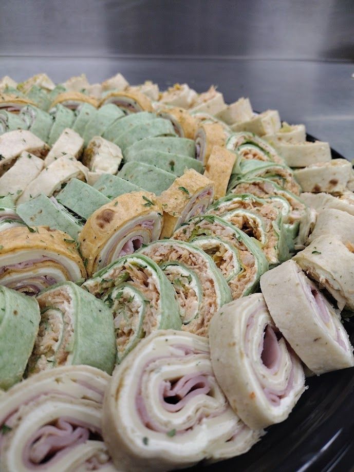A close up of a tray of wraps on a table.