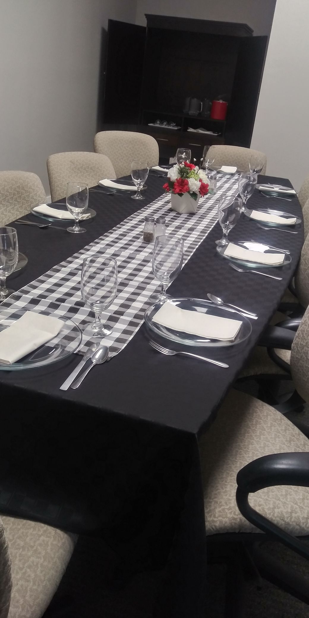 A long table with plates and glasses on it in a room.