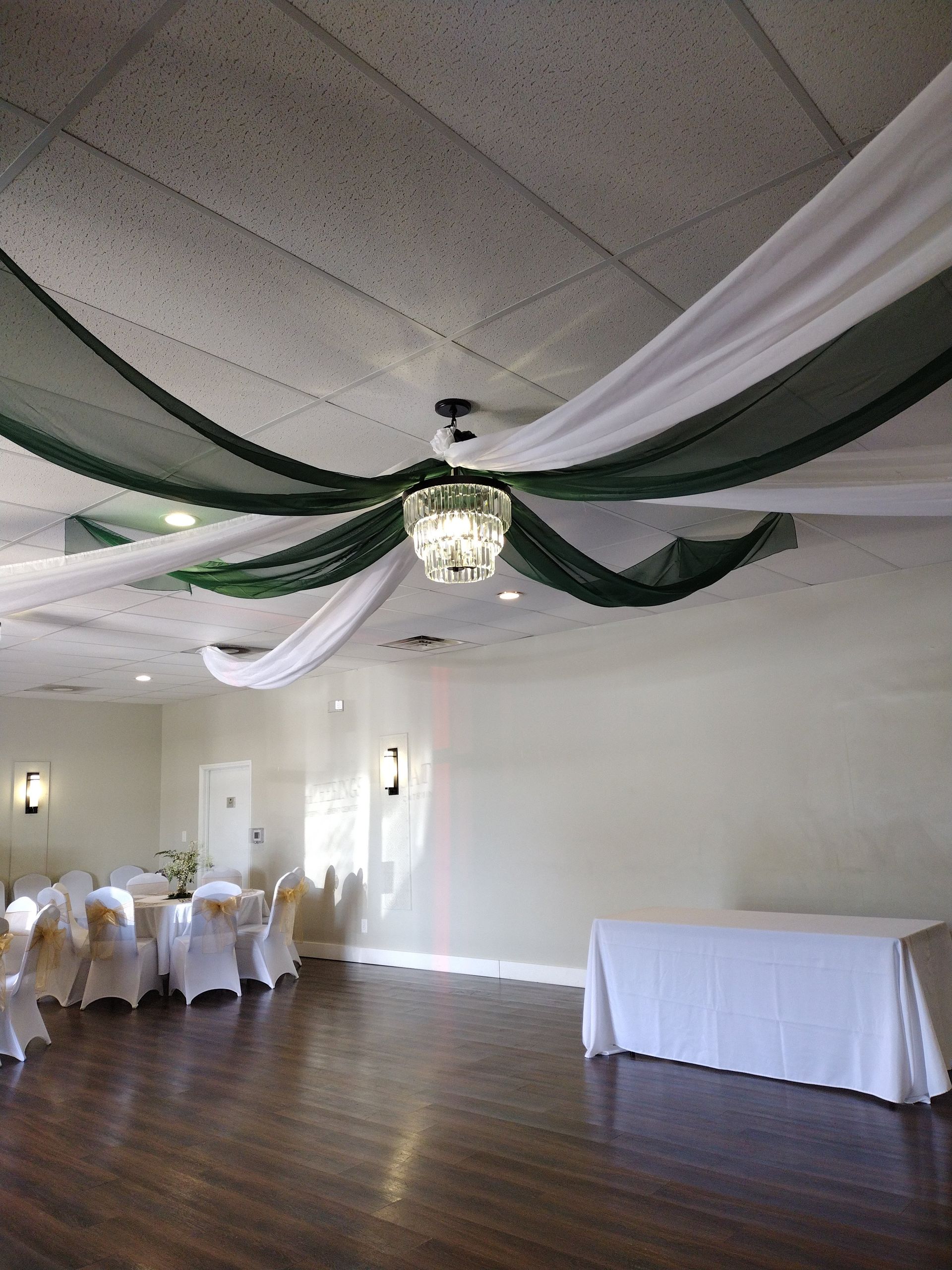 A large room with tables and chairs and a chandelier hanging from the ceiling