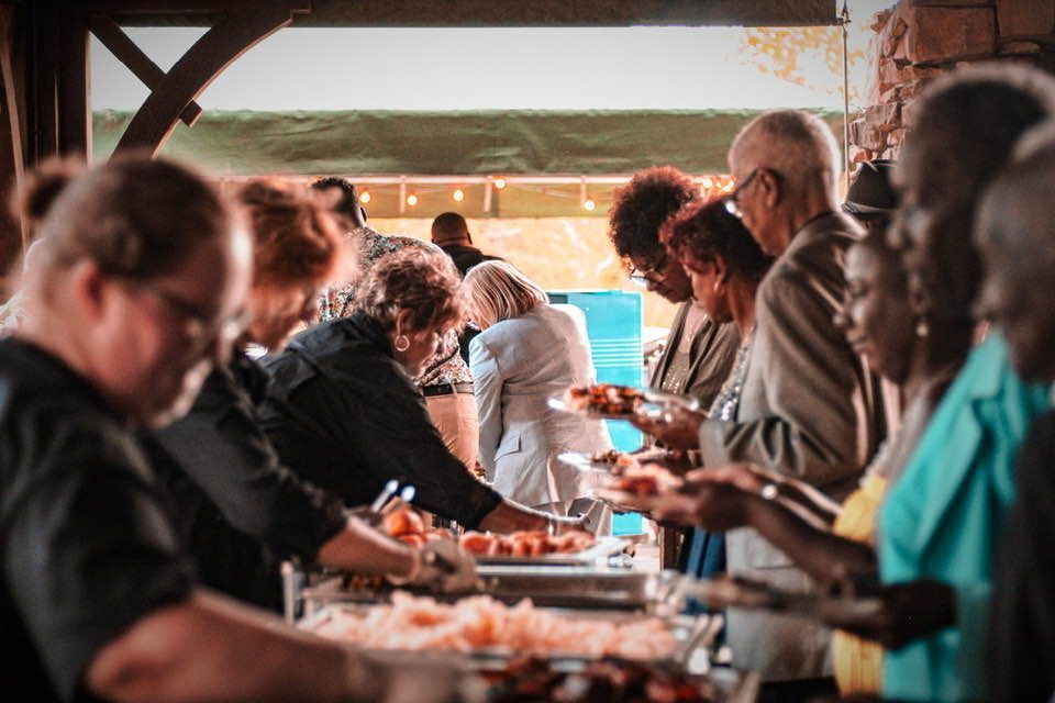 A group of people are standing in line at a buffet table.