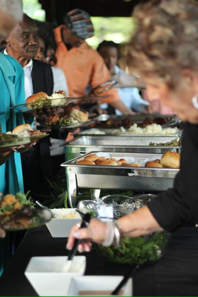 A group of people are getting food from a buffet line