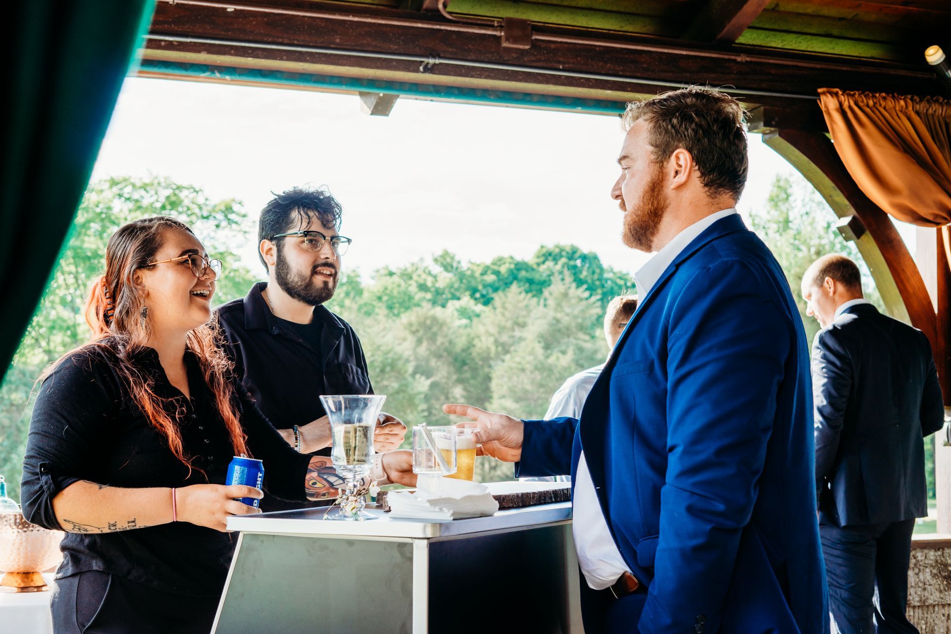 A group of people are standing around a table talking to each other.