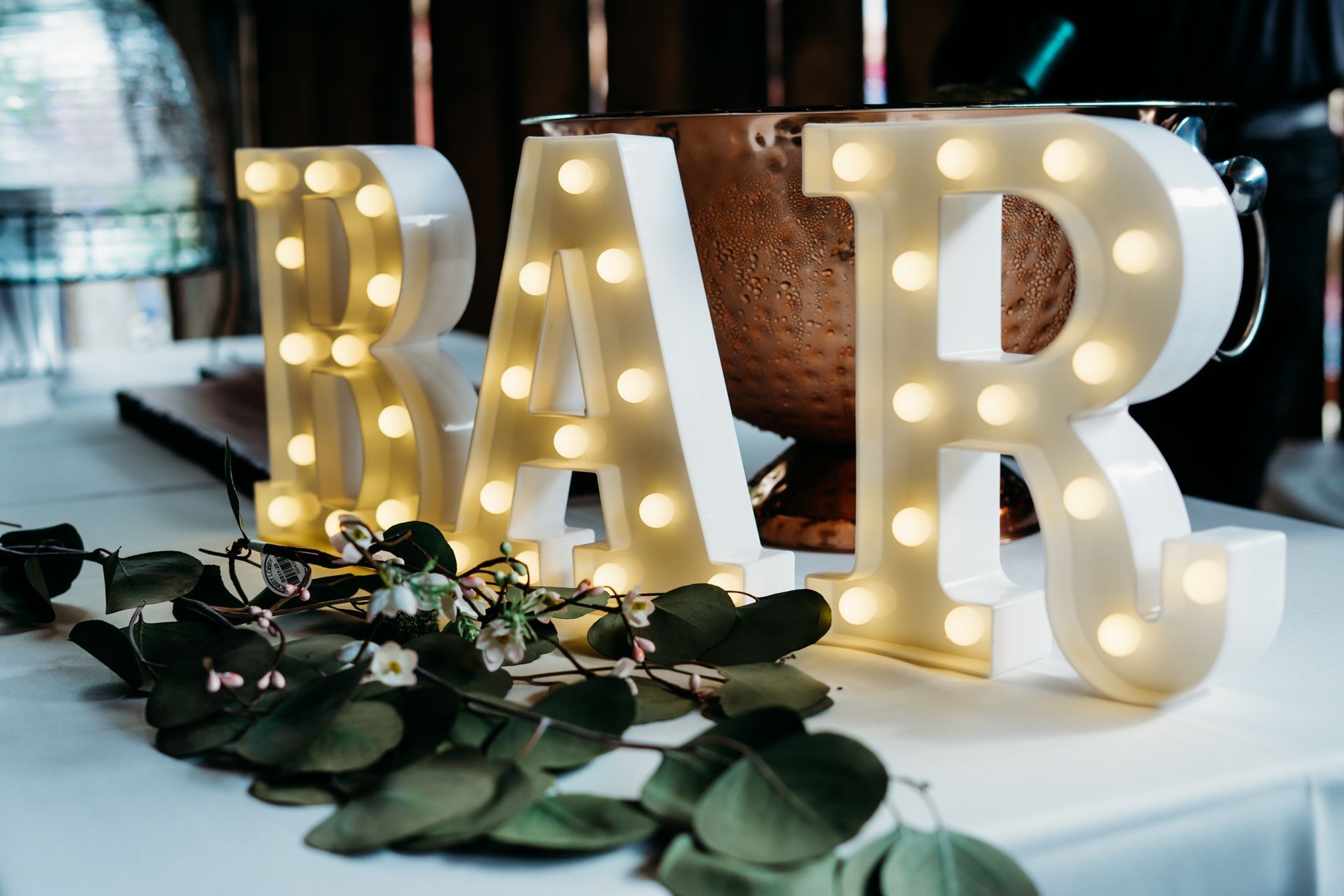 A bar sign with lights on it is sitting on a table.