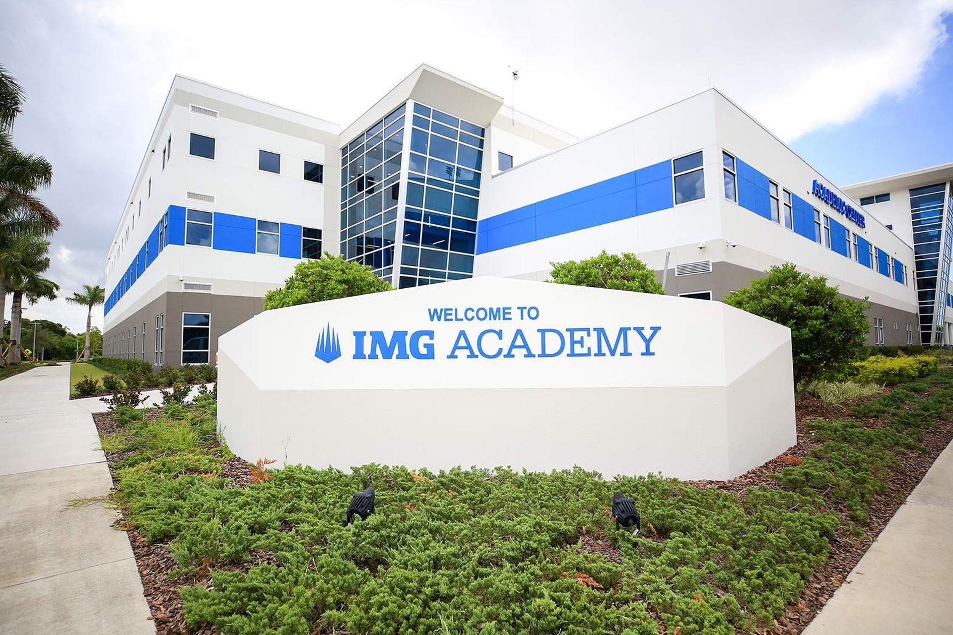 IMG Academy campus entrance with white-and-blue buildings and a welcome sign