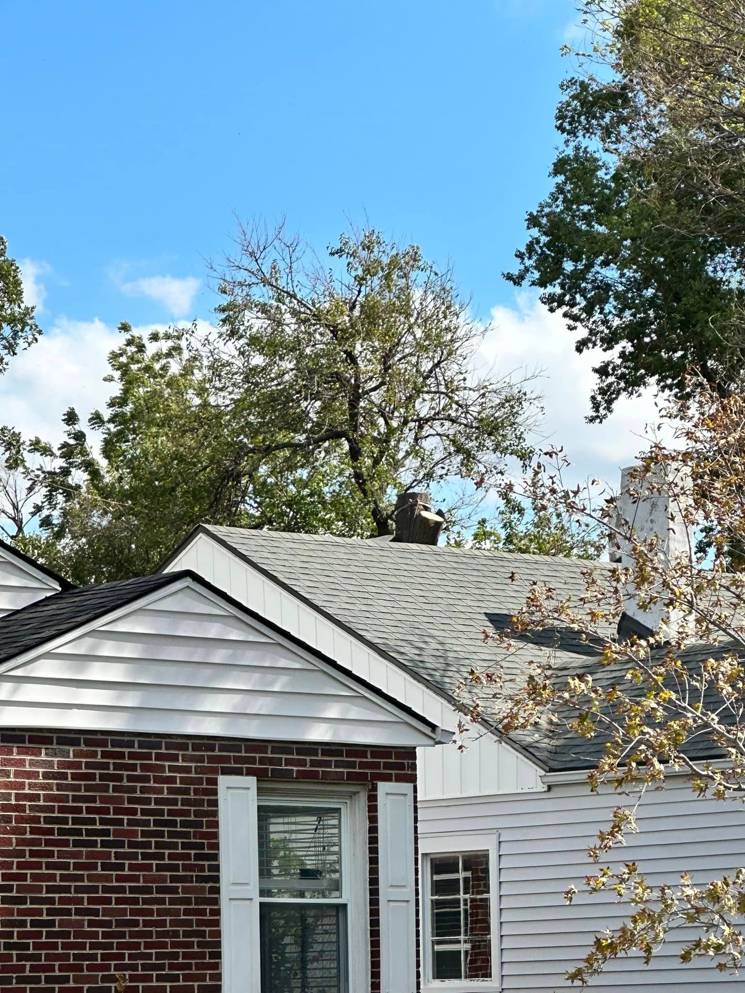A brick house with a white siding and a gray roof