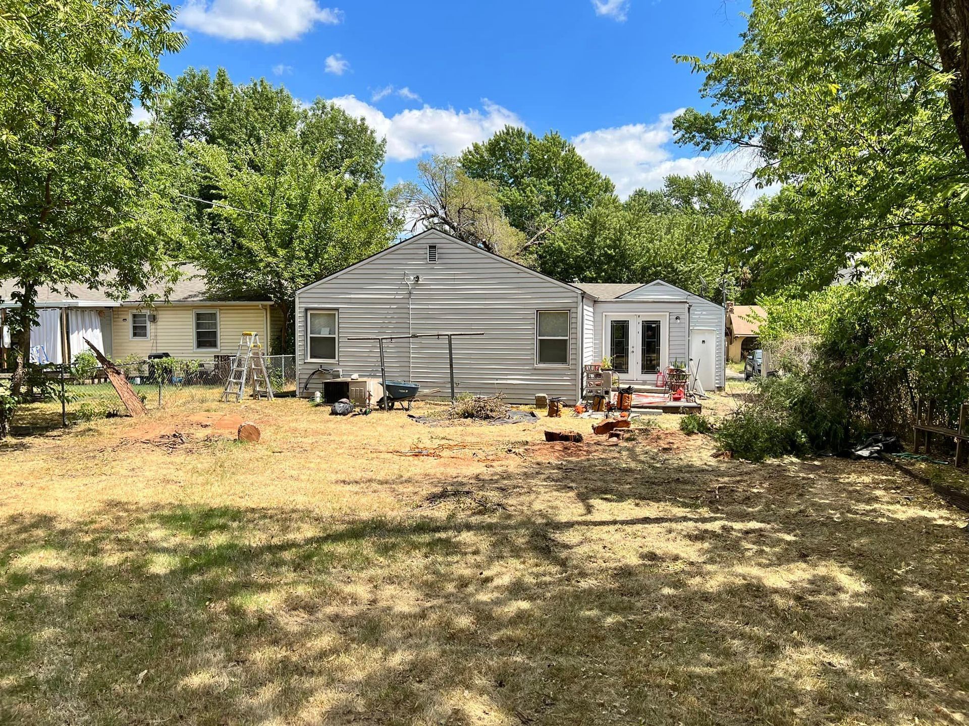 The backyard of a house with a lot of grass and trees.