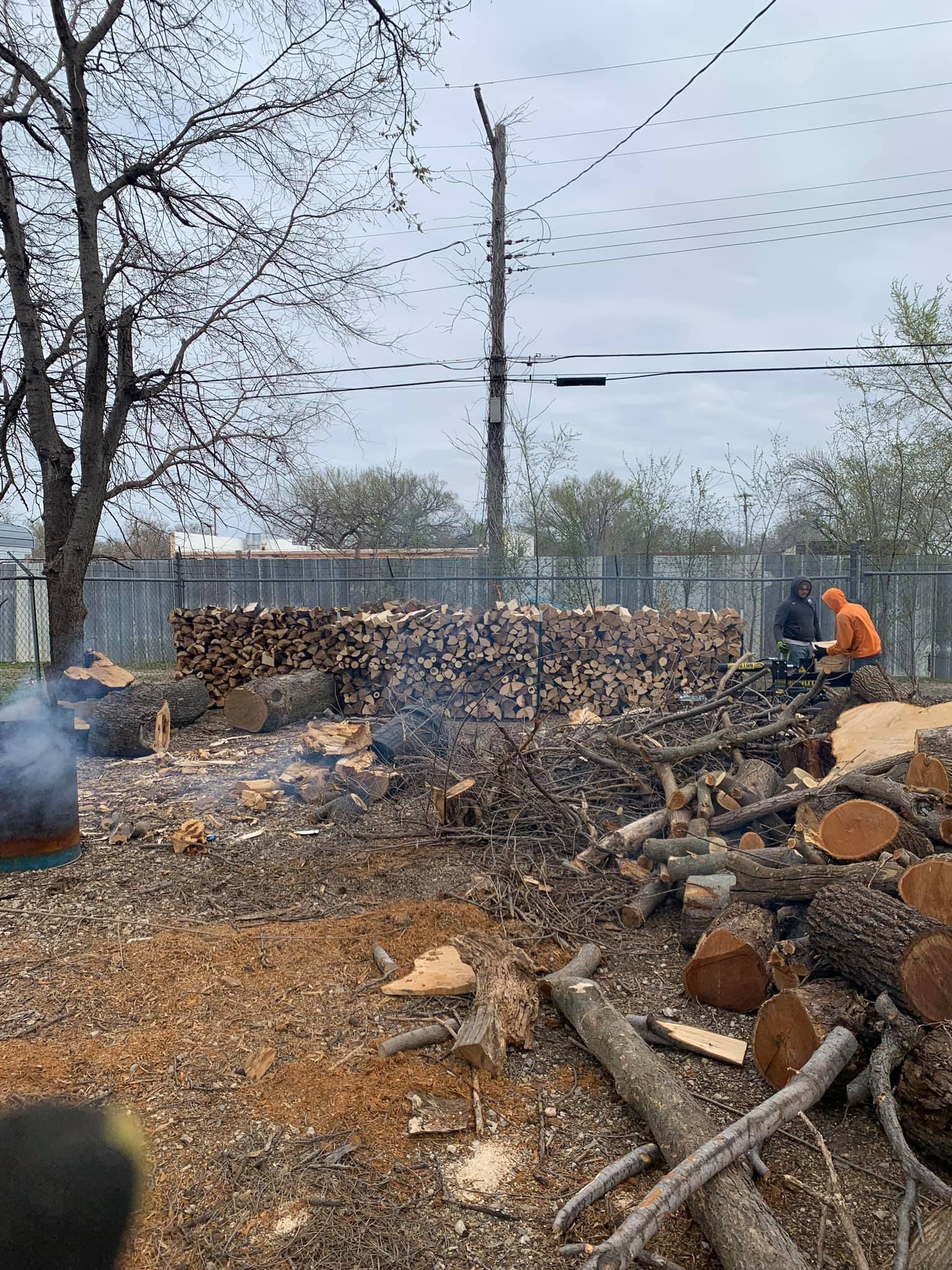 A pile of logs sitting on top of a dirt field.