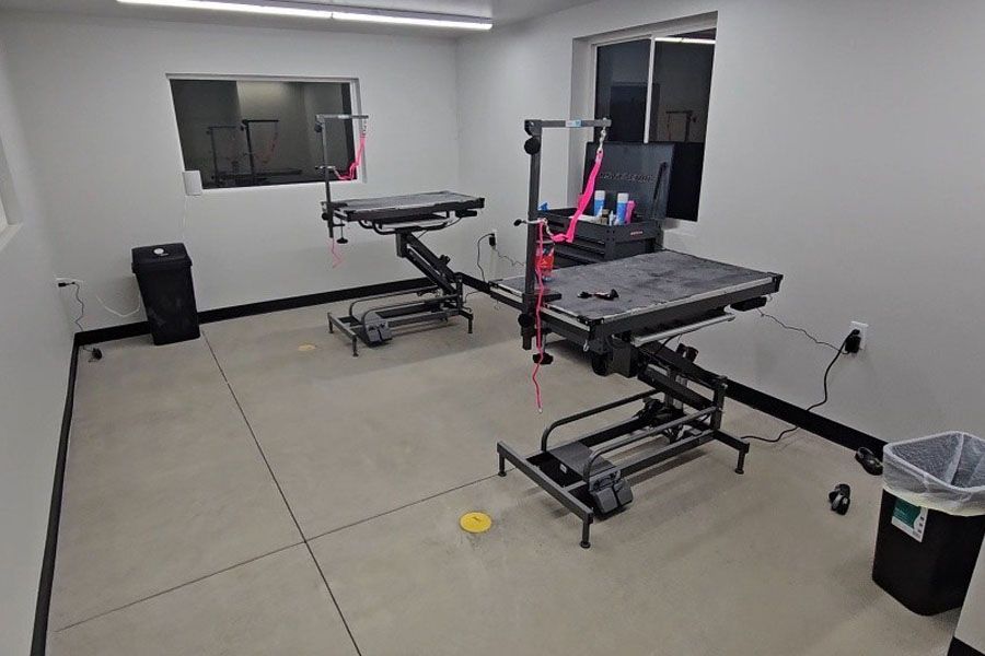 A room with two tables and a trash can in it.