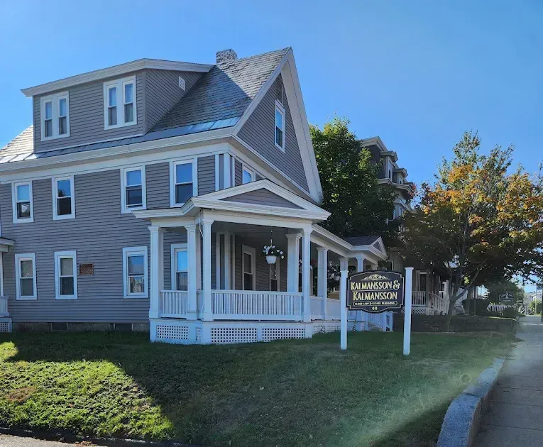 A large house with a porch and a signage