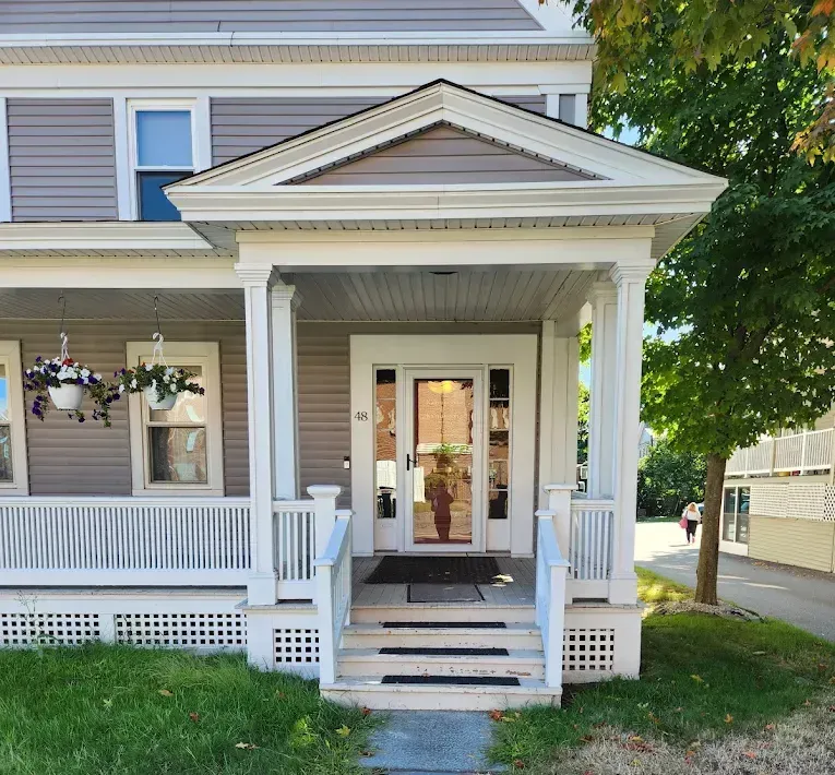 A large house with a porch and a signage