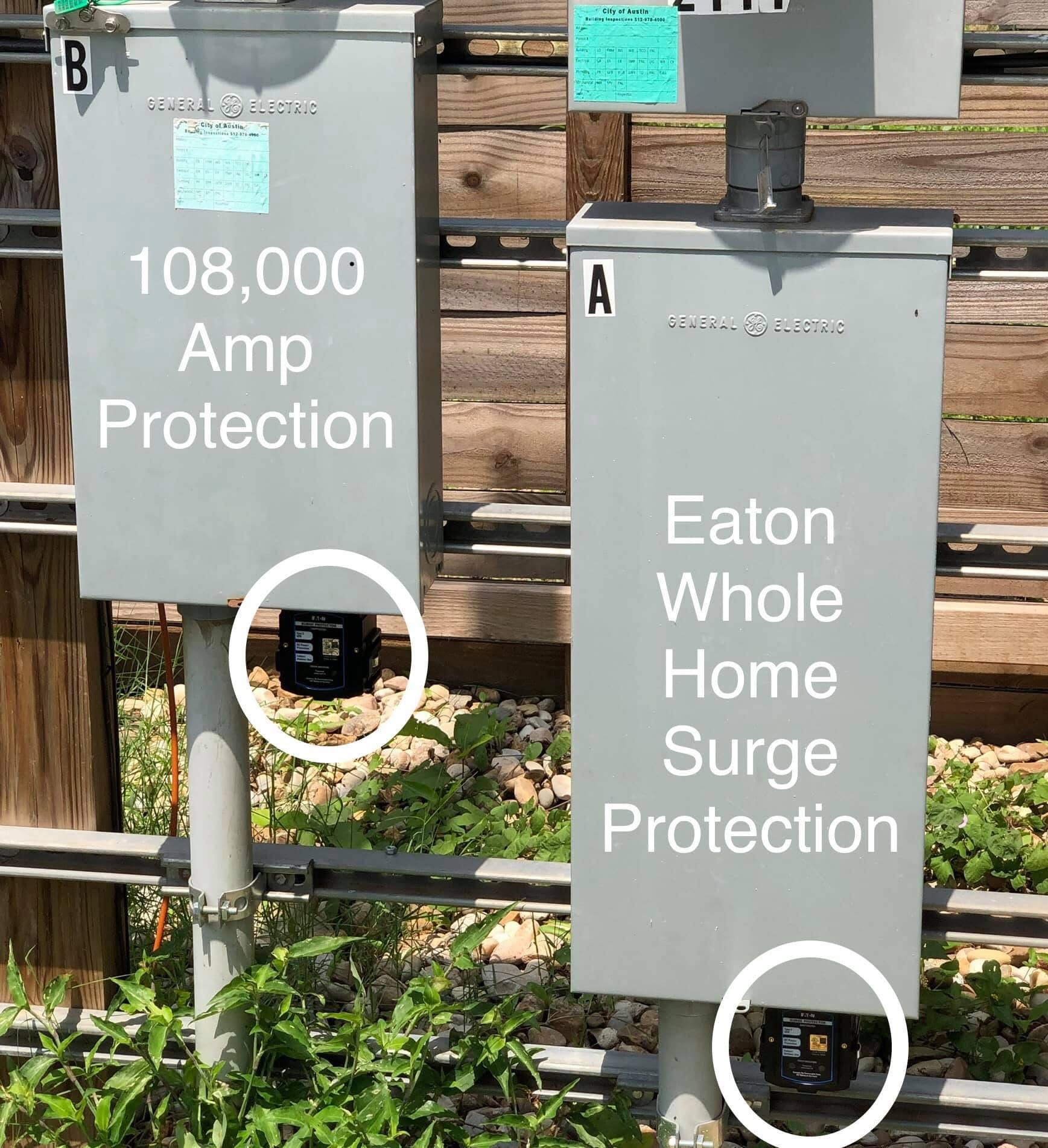 Two gray electrical boxes labeled with amperage and surge protection, mounted outdoors.