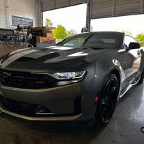 A gray sports car is parked in a garage.