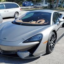 A silver sports car is parked in a parking lot.