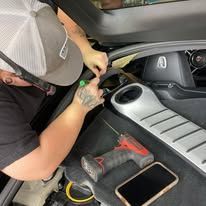 A man is working on the engine of a car.