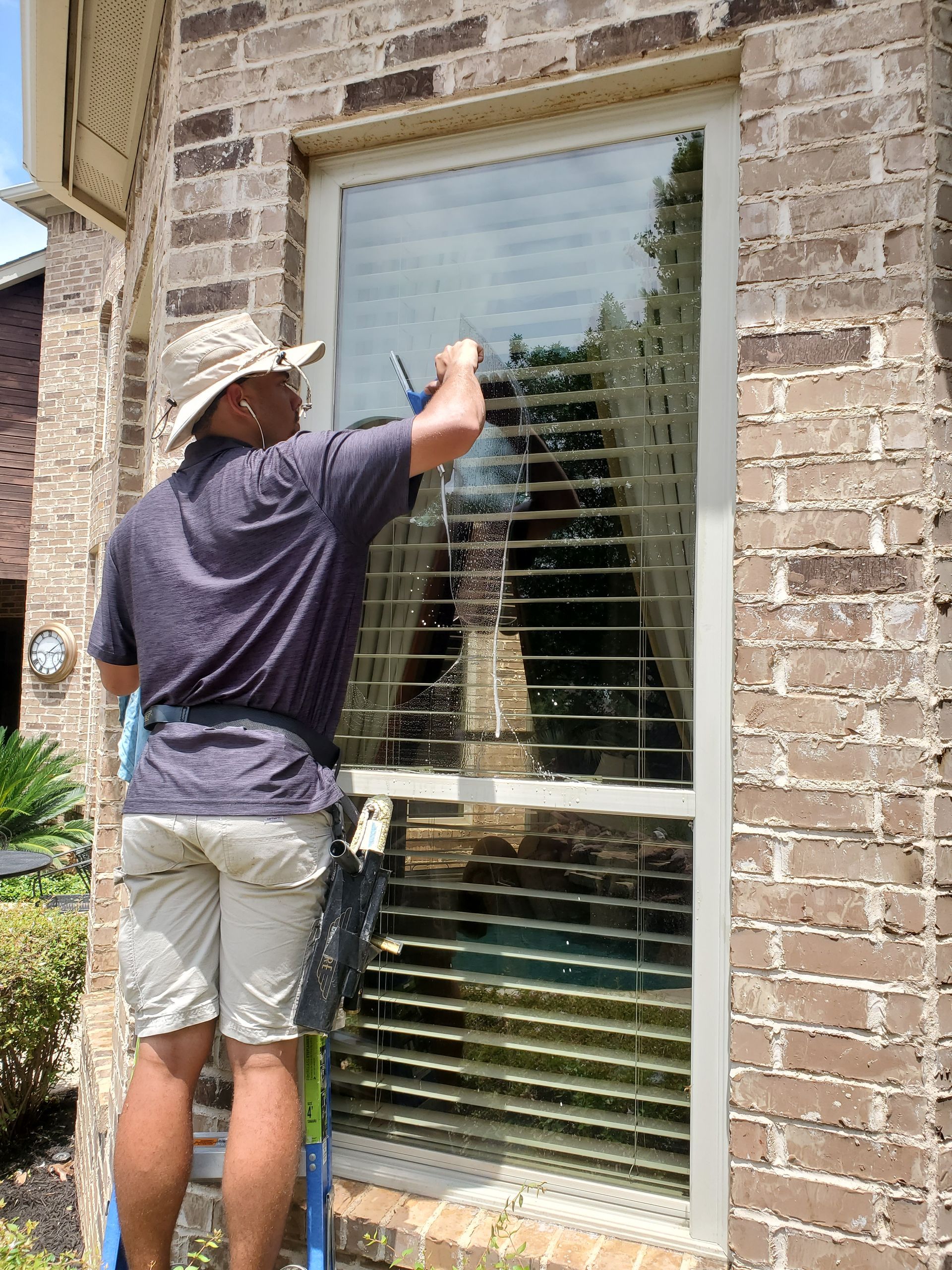 a man is standing on a ladder cleaning a window
