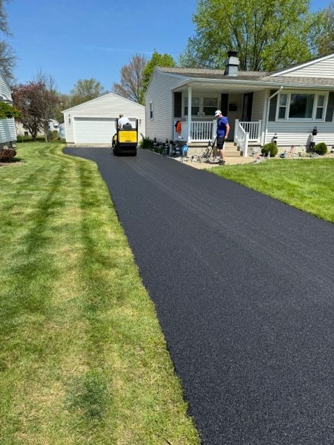 A driveway is being paved in front of a house