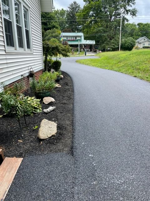 A driveway with a white house in the side