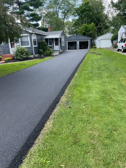 A driveway leading to a house with a truck parked on the side of it