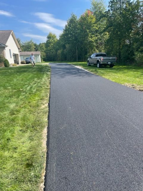 A truck is parked on the side of a road next to a house