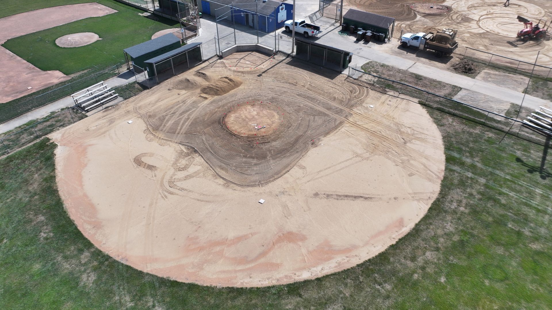 Aerial view of a baseball field with a dirt infield and large circular brown patch in center