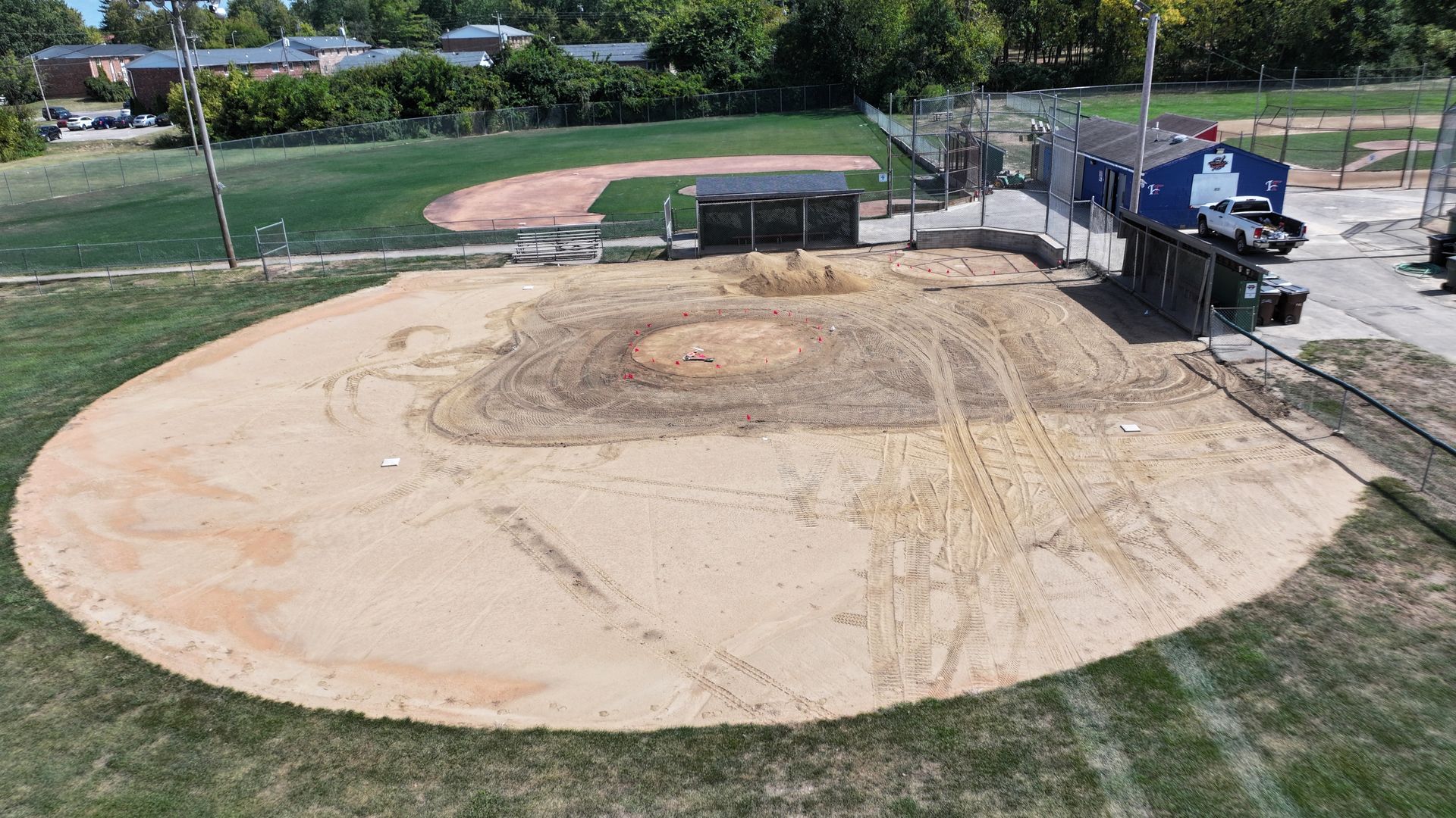 Baseball field under construction with a large dirt infield and heavy equipment nearby