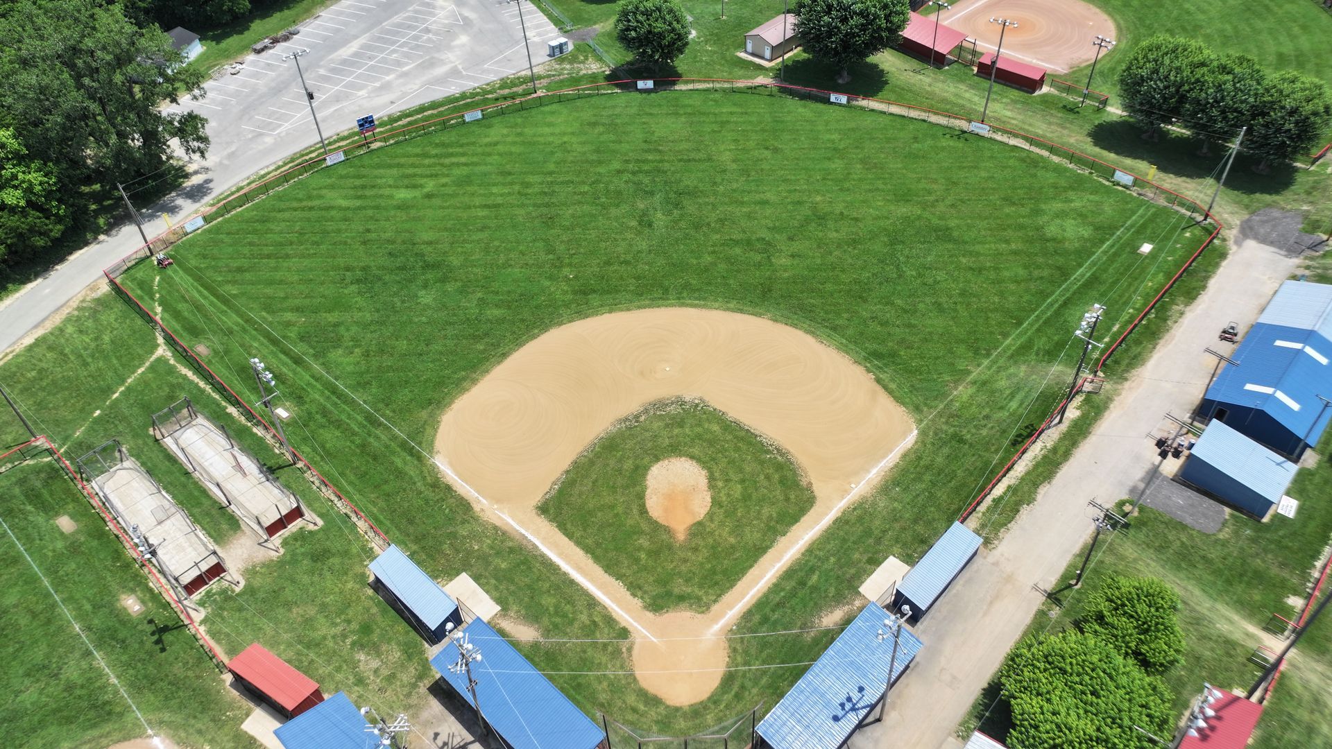 Aerial view of a baseball field with green outfield, tan infield, and dugouts around the diamond