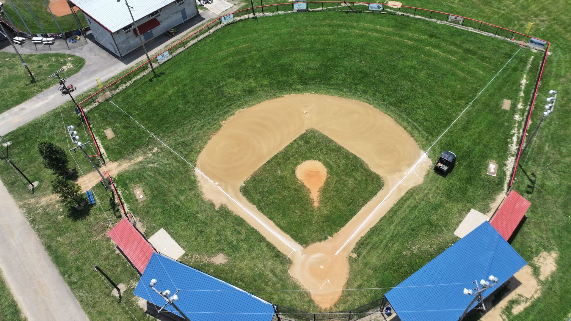 Aerial view of a baseball field with green outfield, tan infield, and blue bleachers along the sides