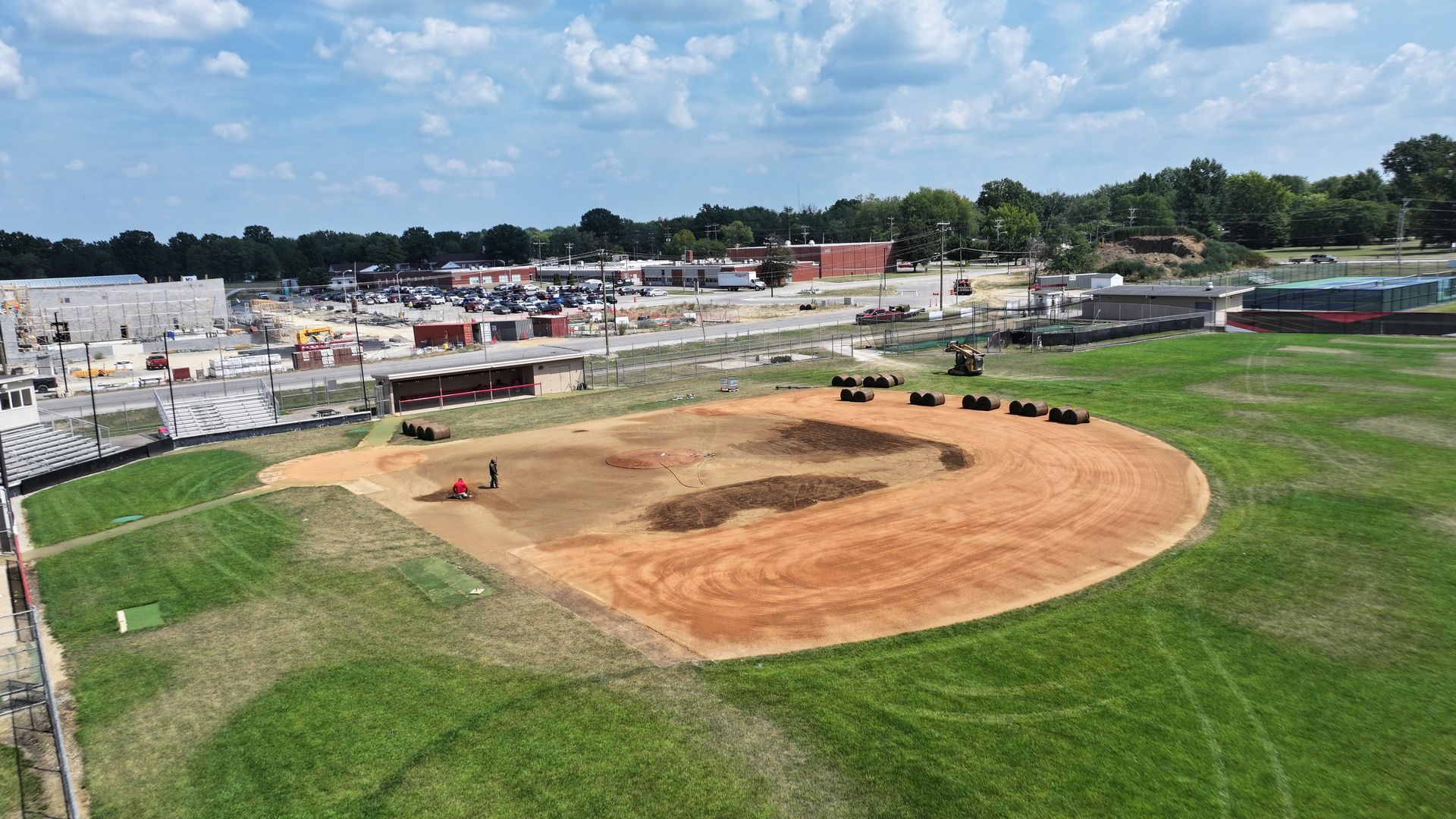 A baseball field under construction with fresh dirt infield and green grass, viewed from above.