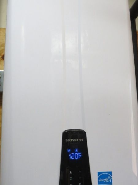 White wall-mounted water heater with a blue digital display reading 120°F.