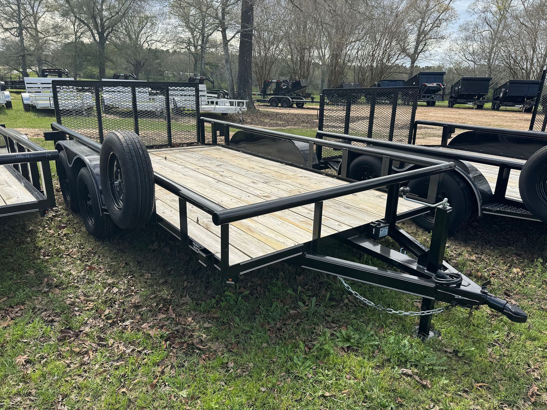 A trailer is sitting on top of a lush green field.